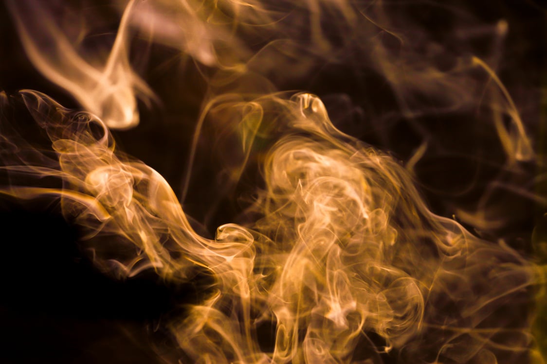 Gold smoke movement on black background.